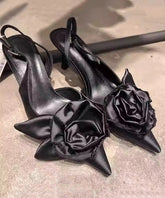 Stilvolle schwarze Sandalen mit Blumenmuster und hohem Absatz und spitzer Zehenpartie